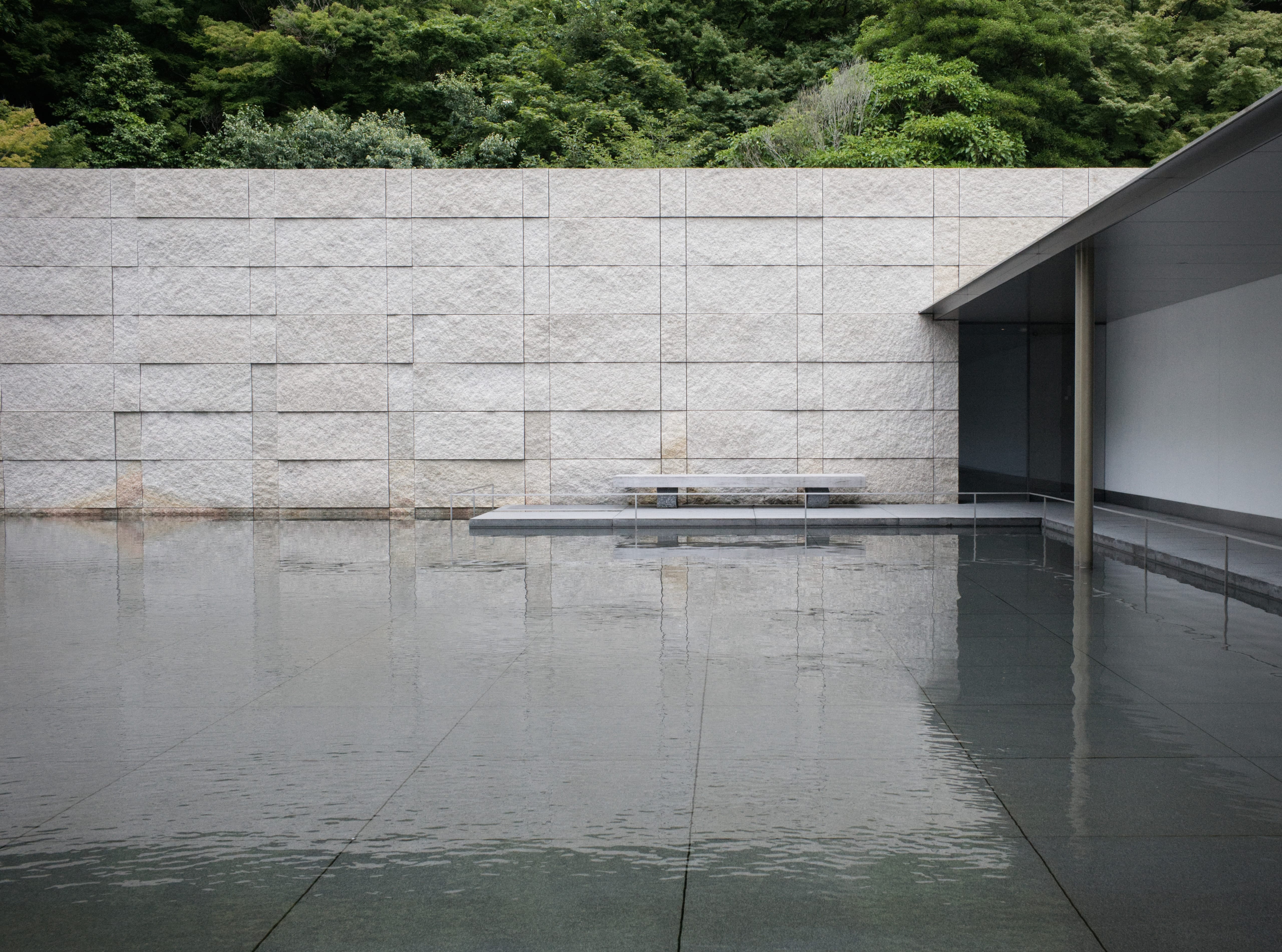 A stone bench beside the reflecting pool at the D. T. Suzuki Museum