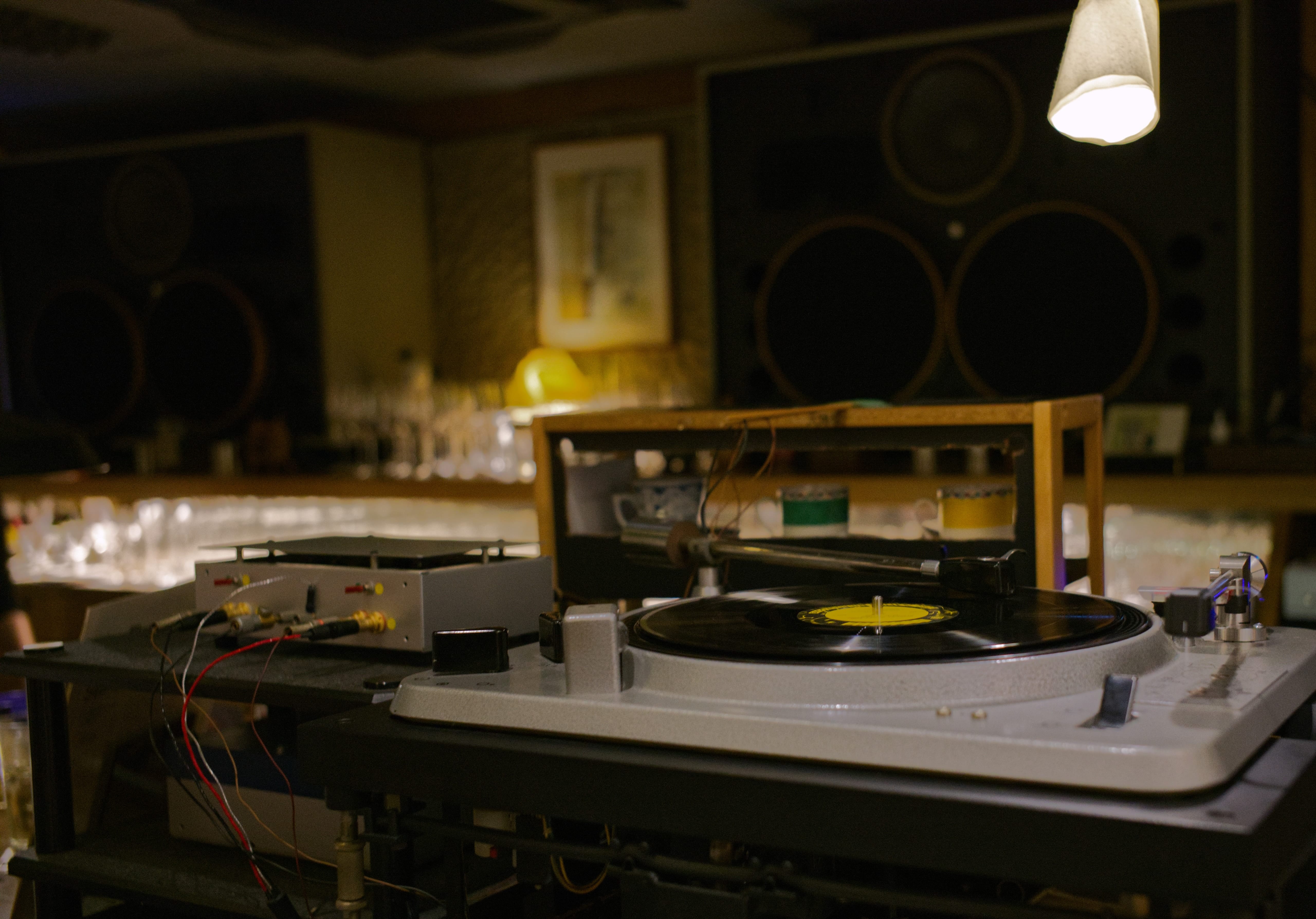A turntable playing a record in front of large speakers at Jazz Spot Bokunen