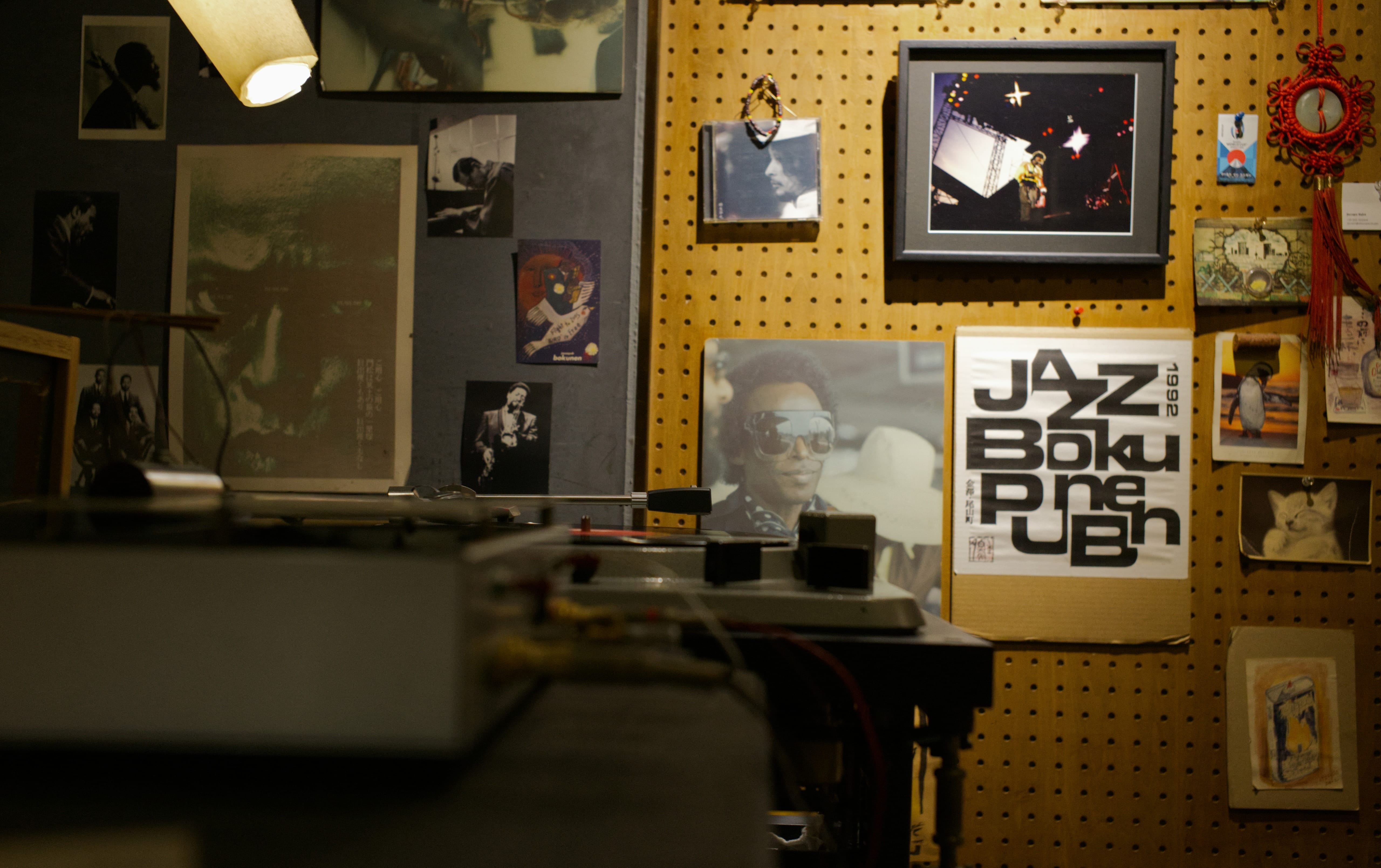 Jazz photos and records on the wall beside turntable equipment at Jazz Spot Bokunen