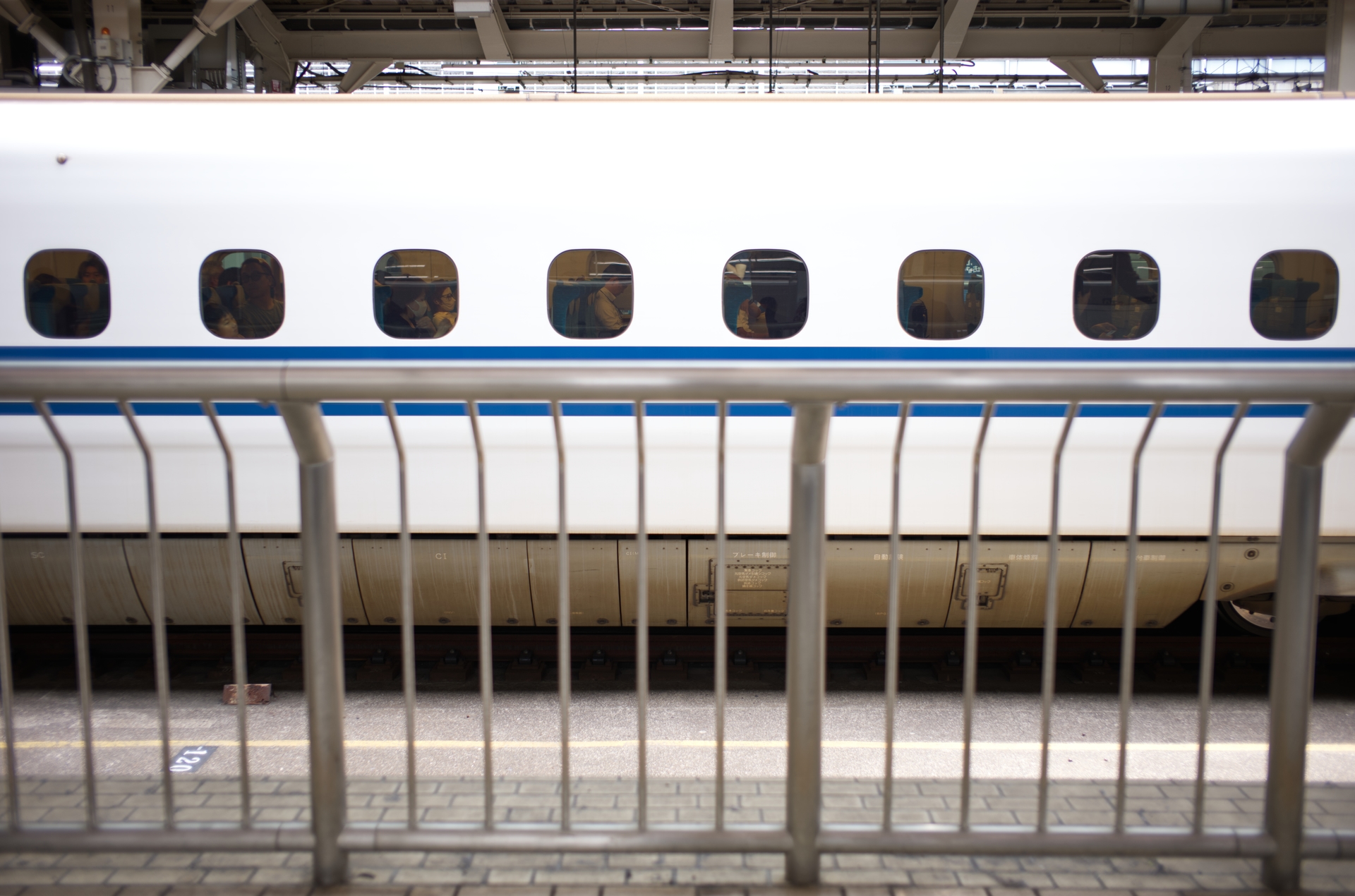 A Shinkansen train behind a platform railing at Tokyo Station