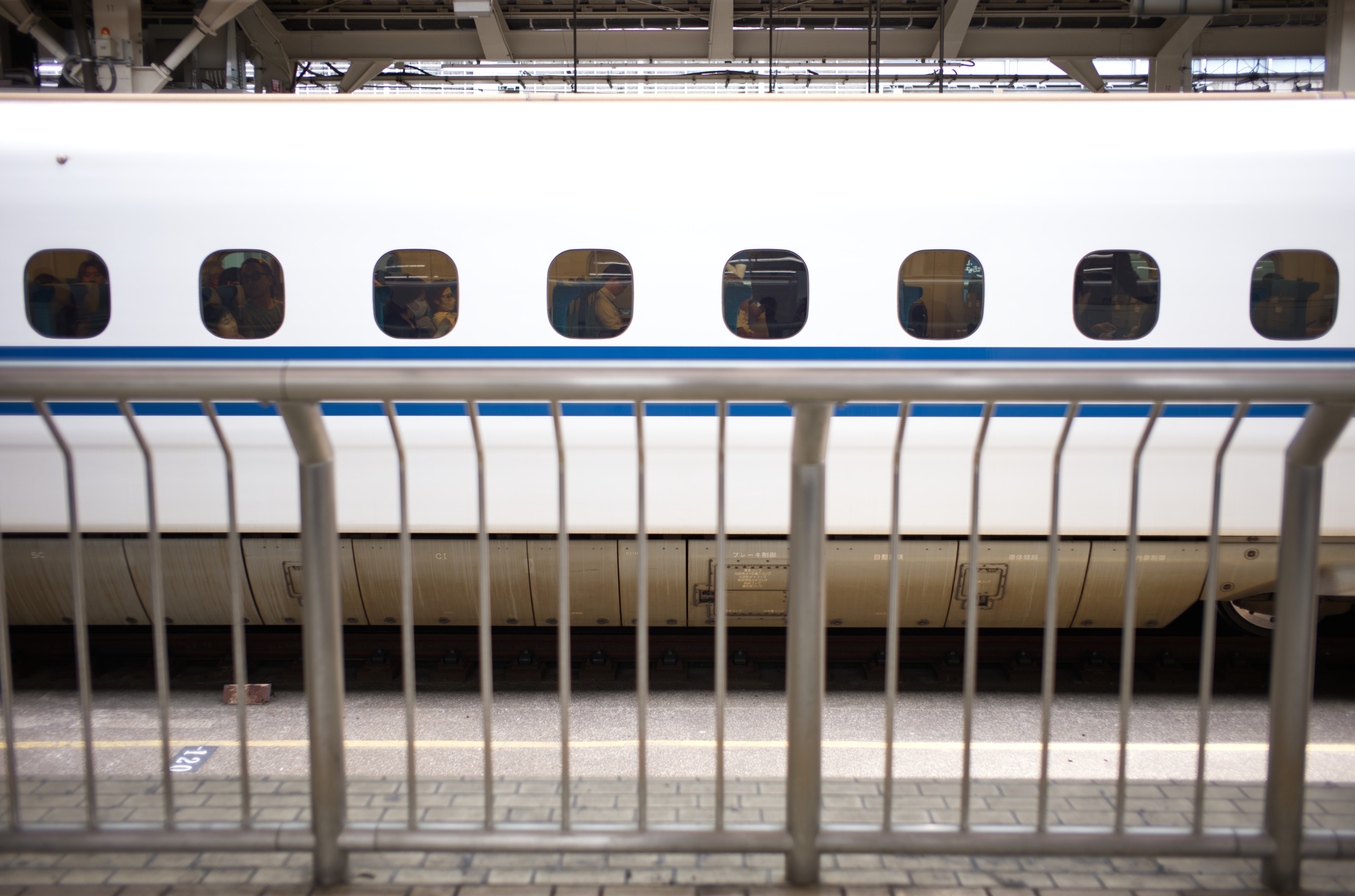 A Shinkansen train behind a platform railing at Tokyo Station