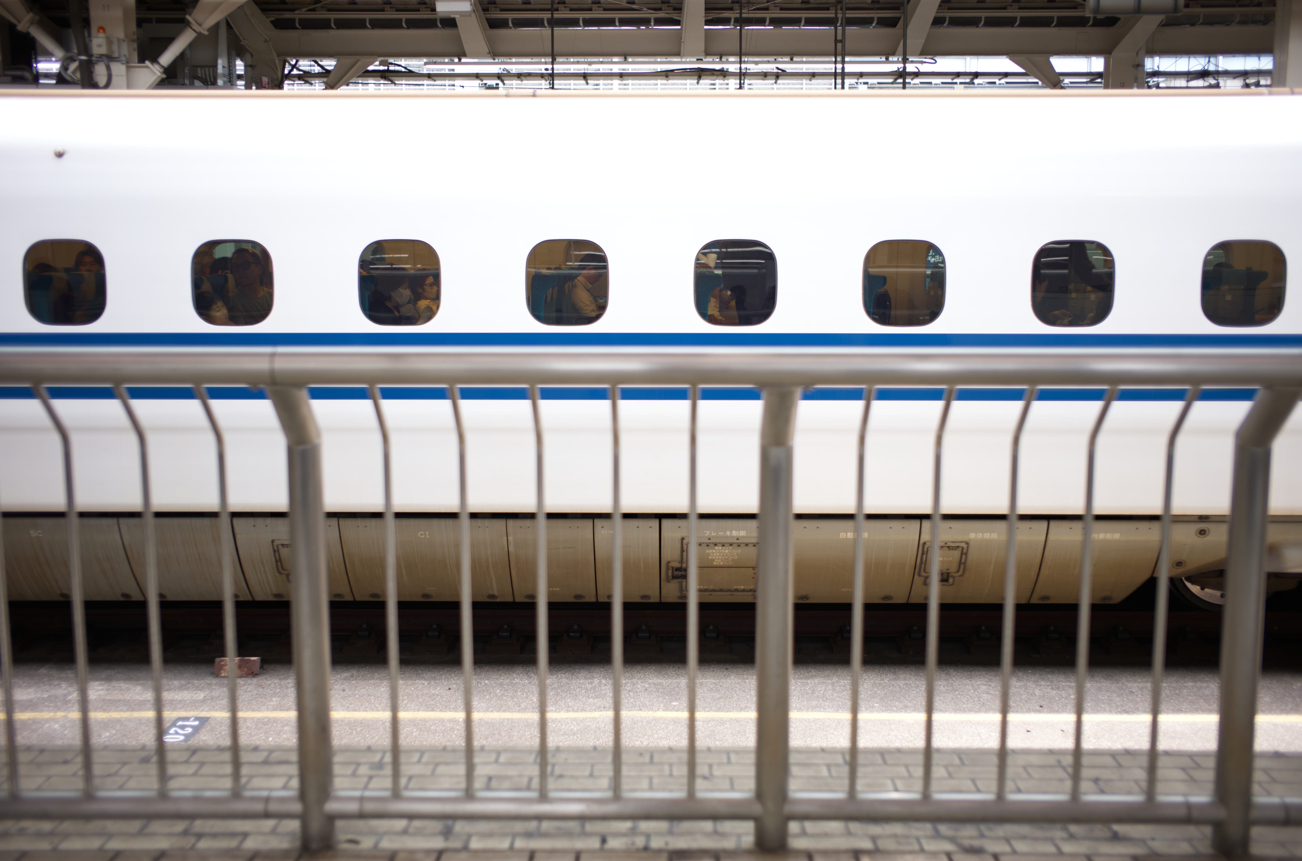 A Shinkansen train behind a platform railing at Tokyo Station