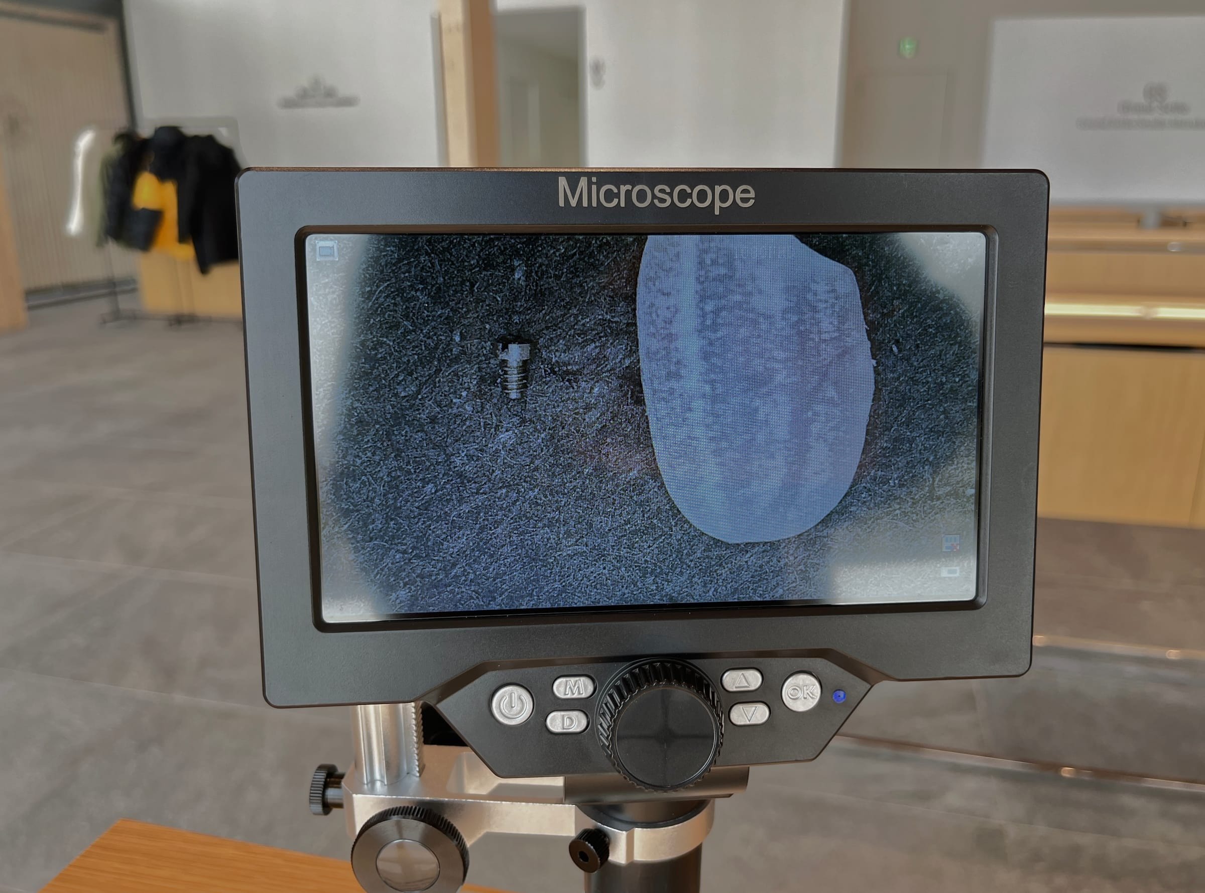 Microscope screen comparing a watch screw to a grain of rice